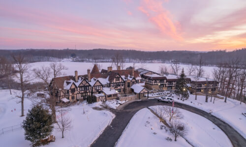 The sun sets over a snowy punderson manor