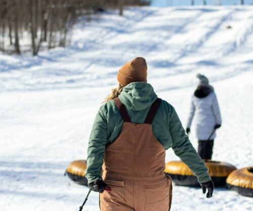Person dragging a snow-tube up hill