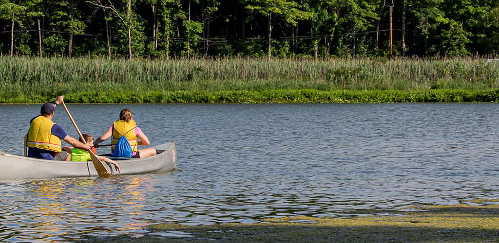 A family canoes at Punderson Manor Lodge's lake